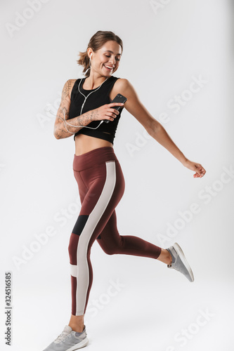 Image of fitness woman running and listening to music with earphones