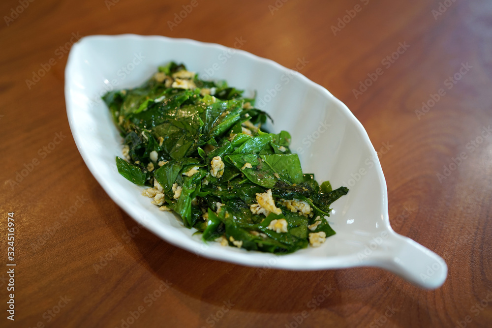 Stir-fried Baegu leaves with egg or Gnetum gnemon or Malindjo, Thai Southern traditional food style. Stir-fried Baegu leaves with egg or Gnetum gnemon or Malindjo, Thai Southern traditional food style.