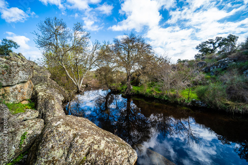 Paisaje con un lago  cielo azul  un puente y nubes