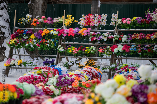 a point of sale with many artificial flowers, bouquets and wreaths near the cemetery sells jewelry and traditional offerings to the graves of the dead in memory of living relatives © Семен Саливанчук