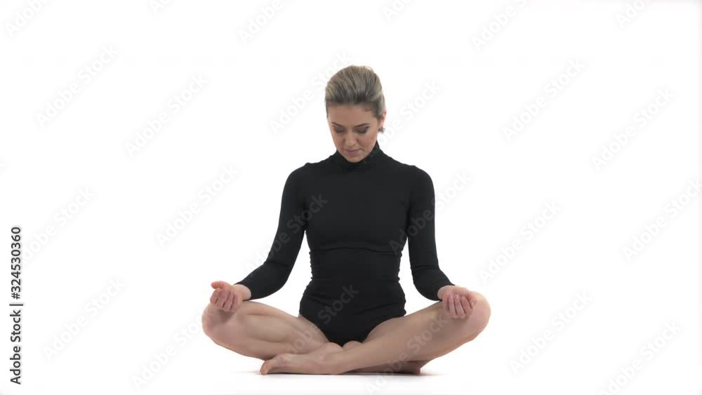 Young woman practicing yoga and sitting in padmasana. Lotus pose Young woman practicing yoga and sitting in padmasana. Lotus pose