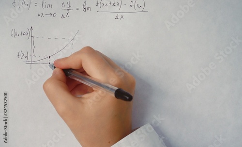 student writes trigonometric formulas on paper	 photo