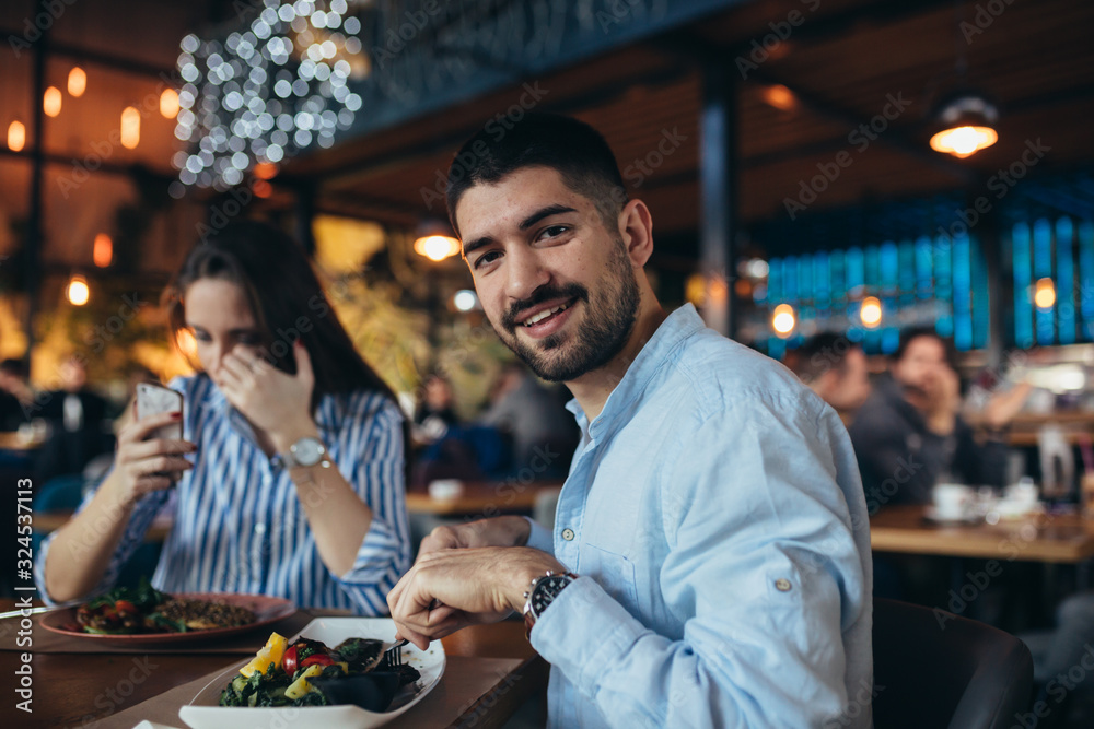 portrait of happy young man having lunch with his girlfriend