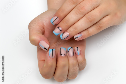 beige manicure with black and blue stripes  circles  abstraction on square nails. Oblique french manicure.