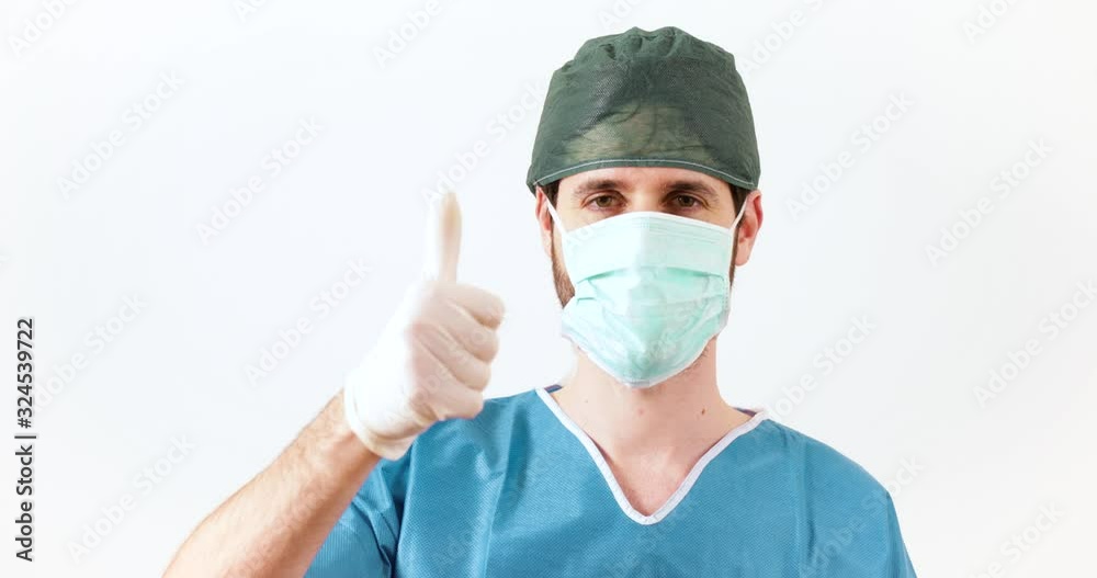 Medico chirurgo fa il pollice in su di fronte uno sfondo bianco. Medico chirurgo fa il pollice in su di fronte uno sfondo bianco.
