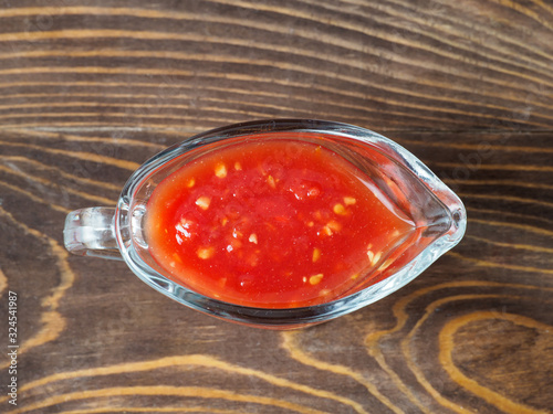 Spicy sauce khrenovina on wooden background.