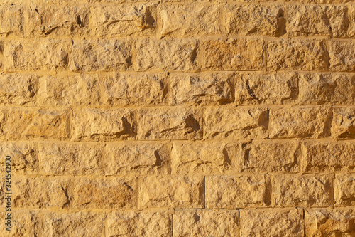 Wall with rough brickwork. Masonry of yellow sand brick blocks. Natural background for decorating modern buildings in the antique style.