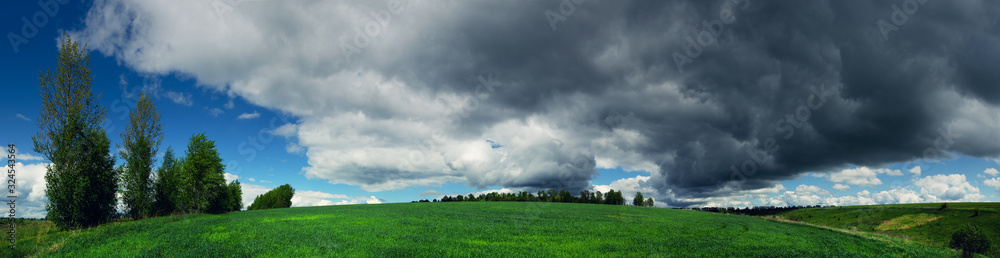 Dark stormy clouds over the green field Dark stormy clouds over the green field