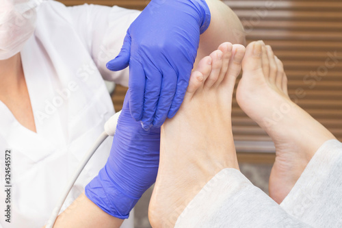 foot treatment. Therapeutic pedicure. Master podologist does hardware pedicure. visit to the podiatry. Foot treatment in the spa. Clinic of Podiatria.