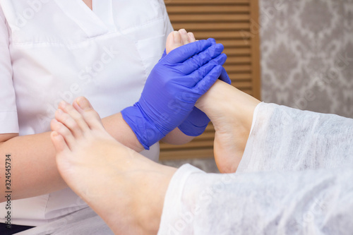Foot massage in spa salon, closeup. foot massage relax skin care. Therapeutic pedicure. © Elena