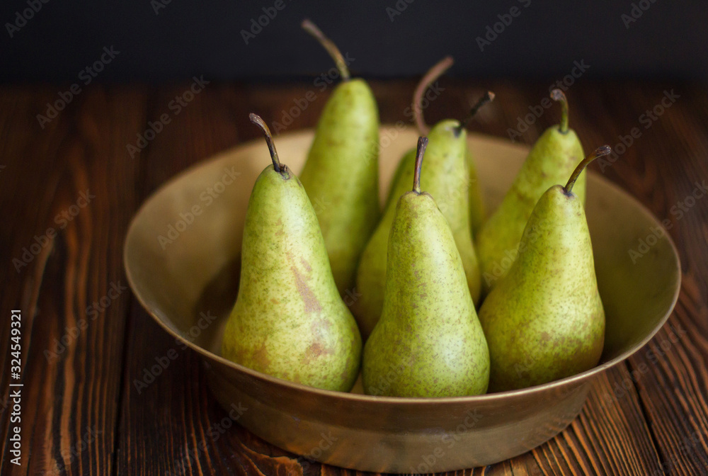 pears in a copper plate on dark background pears in a copper plate on dark background
