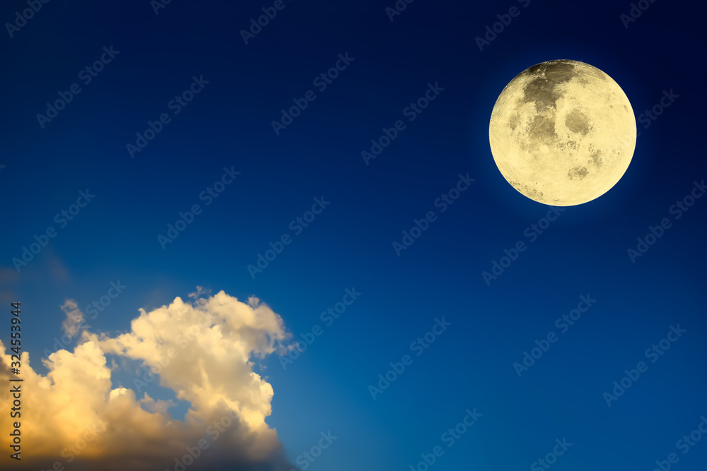 Dramatic atmosphere panorama view of bright and shiny full view of Big Moon on dark blue twilight sky background with golden clouds.Image of moon furnished by NASA.