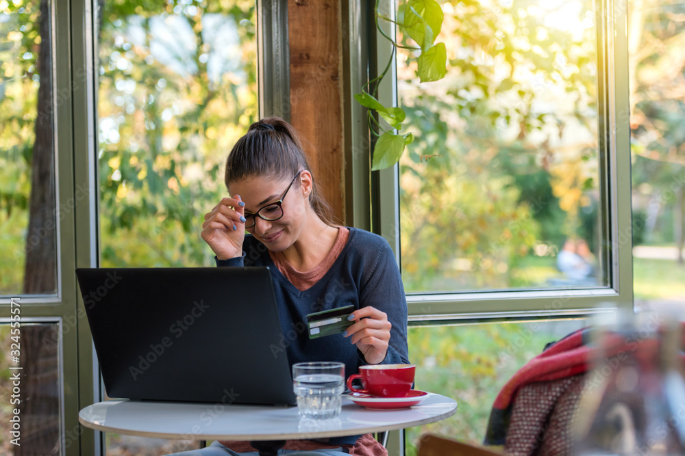 Young woman shopping over internet online in the caffe Young woman shopping over internet online in the caffe