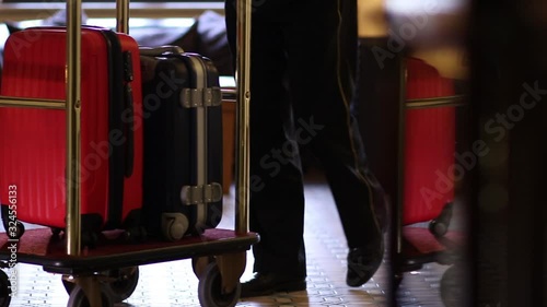 Bellboy carries suitcases in hotel