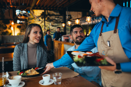 Bilde på lerret waiter serving food to customer in restaurant