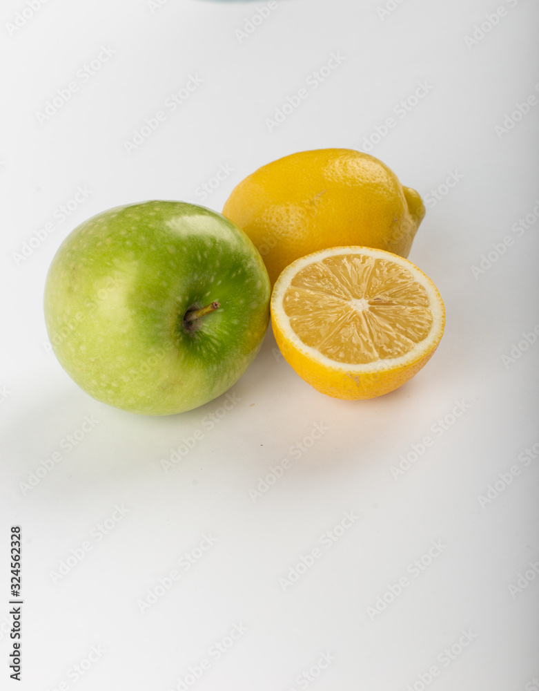Whole and half lemon isolated on white with a green apple Whole and half lemon isolated on white with a green apple