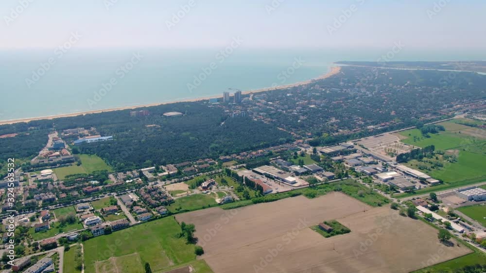 Misty summer day above the Lignano Sabbiadoro, Italy. Aerial cityscape, panning right shot Misty summer day above the Lignano Sabbiadoro, Italy. Aerial cityscape, panning right shot