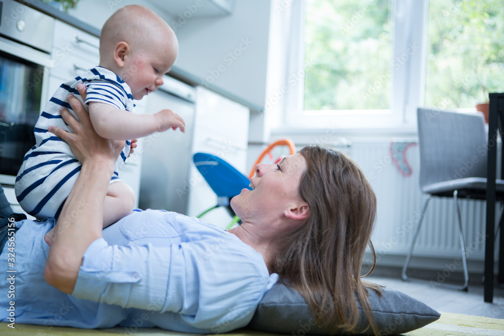 Happy mother playing with her baby at home Happy mother playing with her baby at home