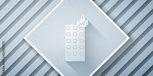 Paper cut Fire in burning building on city street icon isolated on grey background. Paper art style. Vector Illustration
