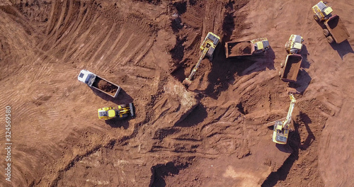 Excavators loading soil onto an Articulated hauler Trucks. Aerial image.