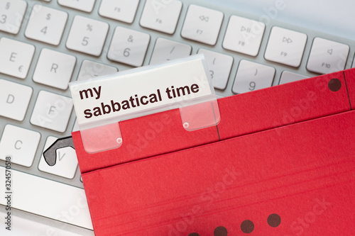 red hanging folder on a keyboard has a tab with the words my sabbatical time on it