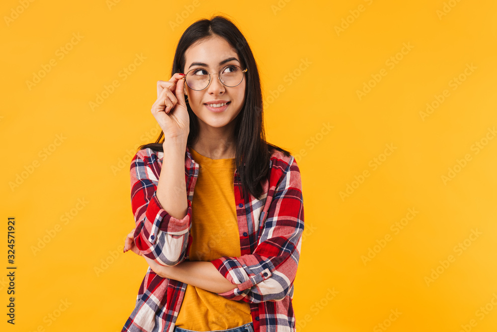 Photo of pleased brunette woman smiling while looking aside Photo of pleased brunette woman smiling while looking aside