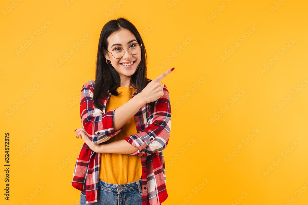 Photo of happy brunette woman smiling while pointing finger aside