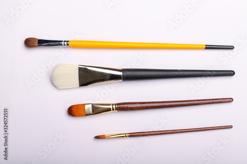 Art brushes of different sizes on a white background. Four painting brushes, horisontal shot