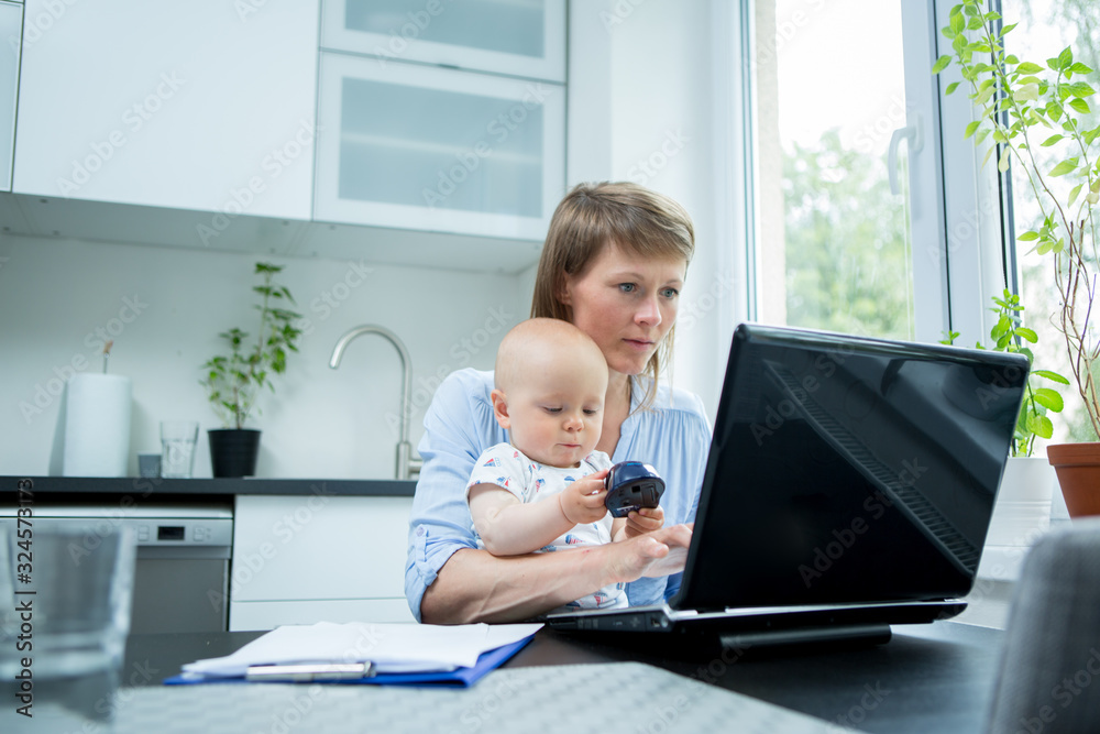 Home office. Mother with cute baby working from home Home office. Mother with cute baby working from home