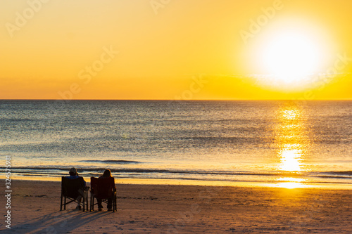 two people sitting on beach enjoying the sunset  © vermontalm
