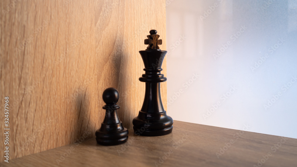 Isolate chess king and queen in wooden background.