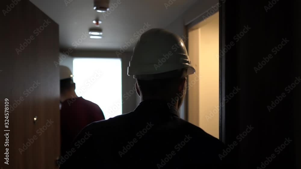 People in construction helmets go on a construction site. Businessmen inspect the building object. Slow motion People in construction helmets go on a construction site. Businessmen inspect the building object. Slow motion