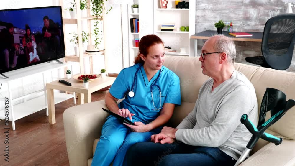 Female caregiver helping old man in nursing home Female caregiver helping old man in nursing home