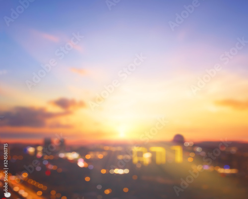 World city day concept: blurred city on sunset sky background