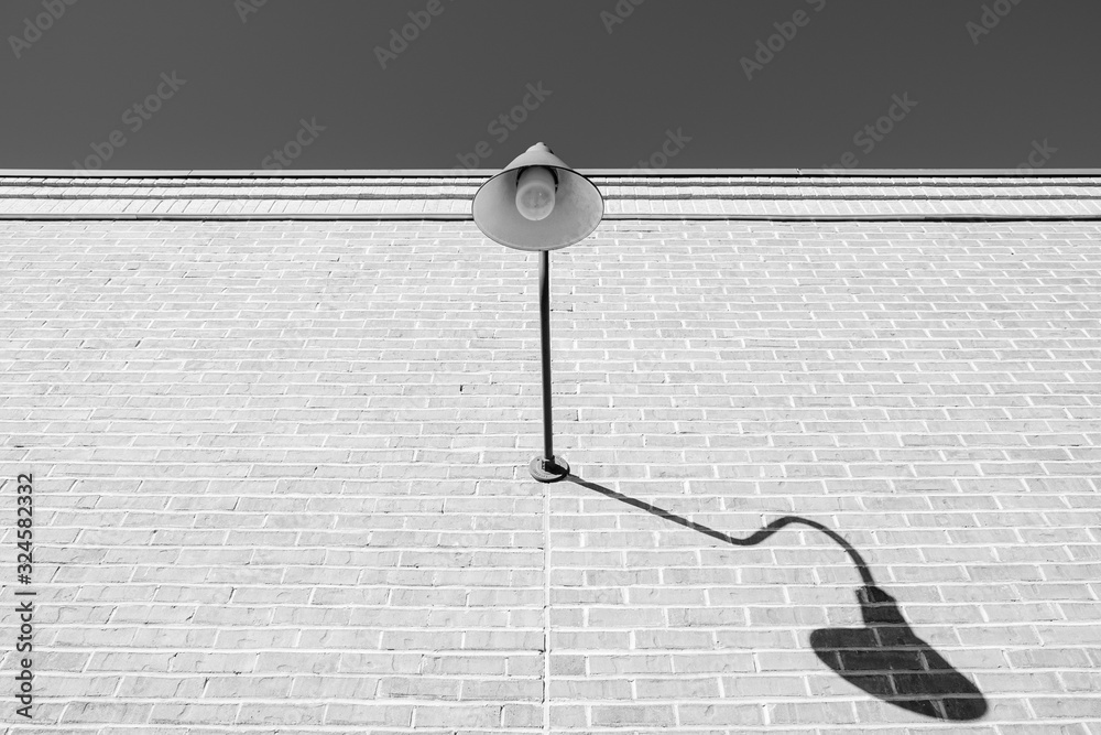 Isolated exterior wall design lighting. Brick wall with exterior halogen lamp. Decorative curved exterior wall lighting. 