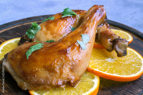 chicken legs glazed in honey sauce with oranges.