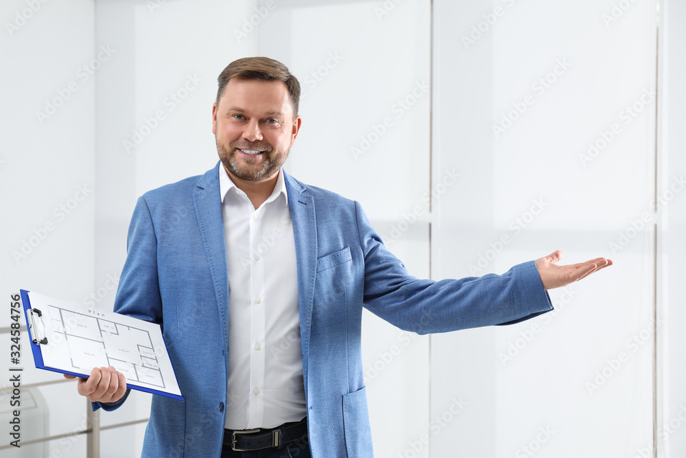 Male real estate agent with clipboard in new apartment Male real estate agent with clipboard in new apartment