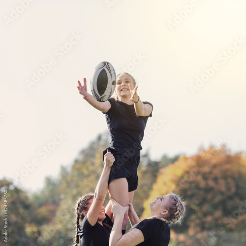 Girl catching a ball helped by her team mates