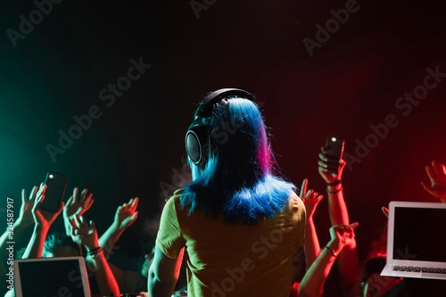 Bild auf Leinwand Front view female dj at soundboard in club
