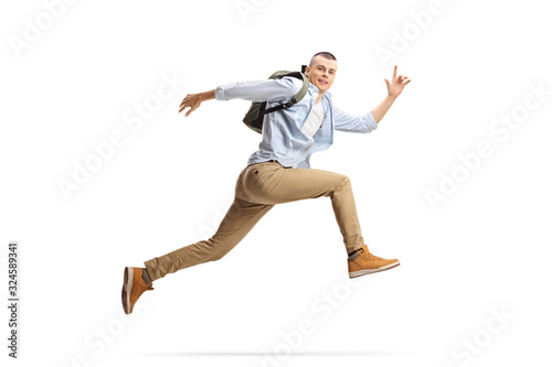 Male student with backpack jumping