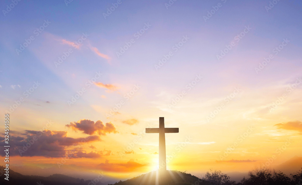 Silhouette cross on mountain sunset background