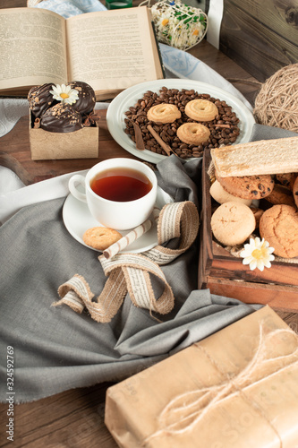 A cup of tea, chocolate pralines and a tray of cookies