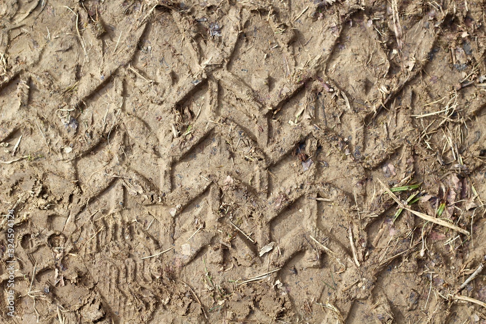 A close view of the tire track in the dirt surface. A close view of the tire track in the dirt surface.