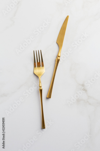 golden fork and knife on a white serving table