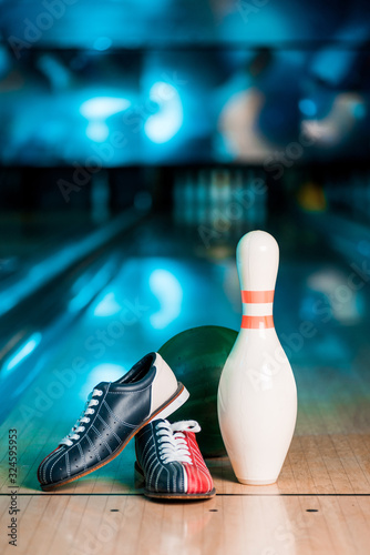 selective focus of bowling shoes, ball and skittle on bowling alley photo