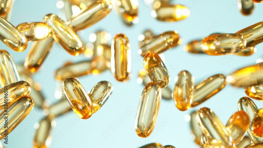 Super Slow Motion Shot of Flying Golden Capsules on Gradient Background at 1000fps. Super Slow Motion Shot of Flying Golden Capsules on Gradient Background at 1000fps.