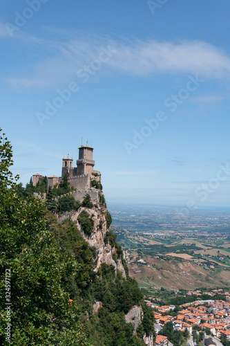 The fortress, first tower, at the foot of the mountain city. Summer sunny day. Pass of the witches. vertical photo Fortification on top of the mountain, old castle. Vertical photo. San Marino, Italy