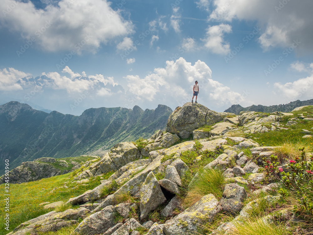 man standing on a stone in the Dolomites with high mountains in the background
