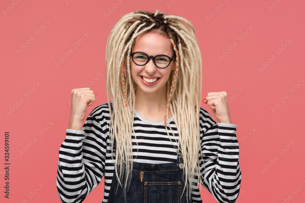 Lucky young girl with long dreads showing gesture of success Lucky young girl with long dreads showing gesture of success