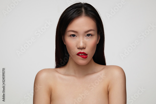 Tablou pe pânză Indoor shot of flirty young brown-eyed brunette female with festive makeup bitin